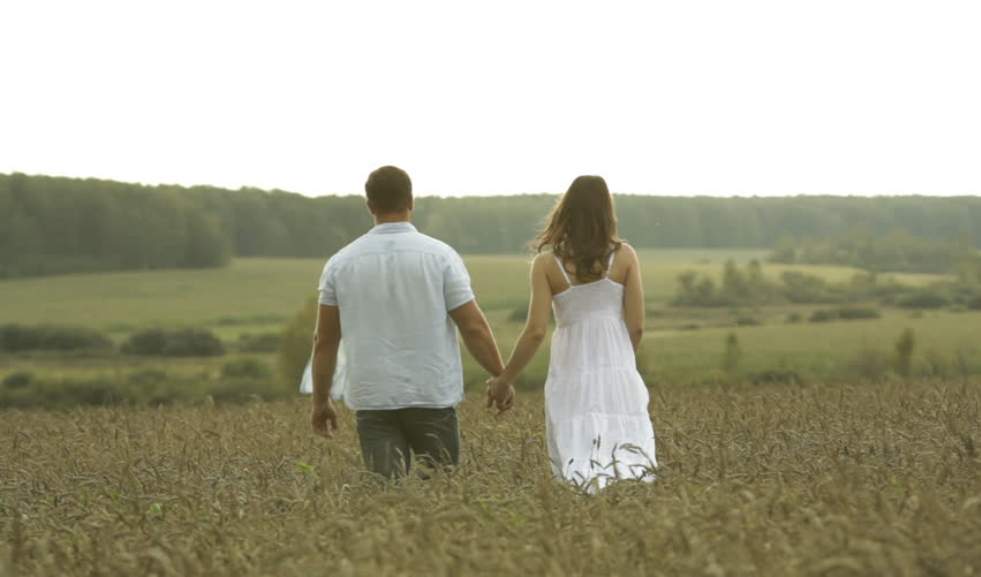A couple holding hands in a field